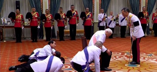Ενθρόνιση του νέου βασιλιά της Ταϊλάνδης. Μπροστά του, σερνάμενοι στο πάτωμα ανώτατοι αξιωματούχοι του κράτους, μεταξύ των οποίων και ο πρωθυπουργός.
